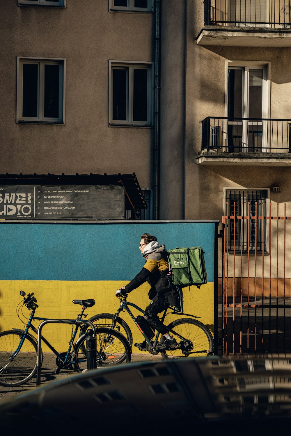 a man riding a bike down a street next to a tall building