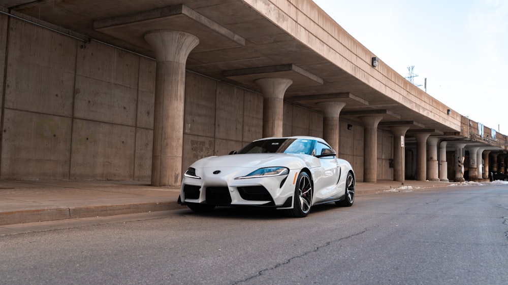 a white sports car parked on the side of a road