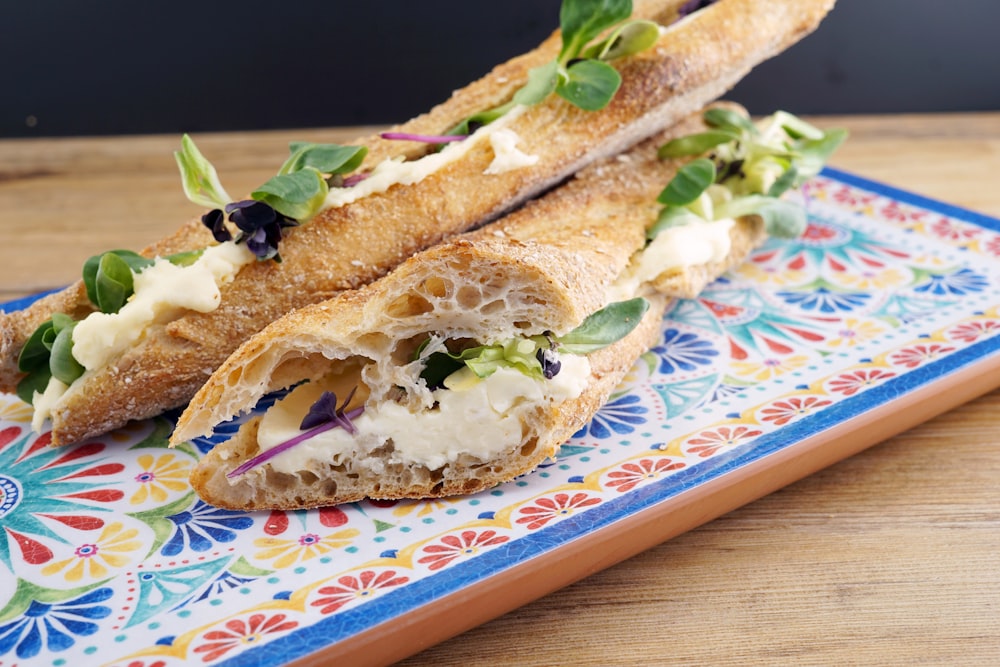 a sandwich cut in half on a colorful plate