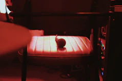 A serene moment captured during a recorded music session, with vintage microphones and dark blue ambient lighting.
