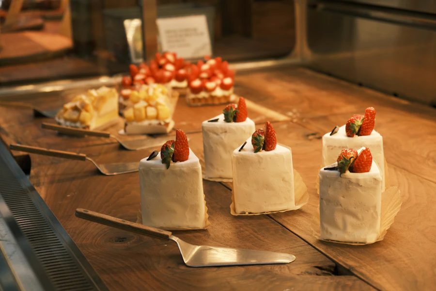Petite Korean cream cakes topped with fresh strawberries in a bakery case