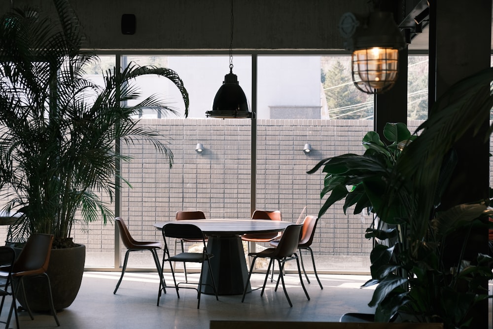 a table and chairs in a room with large windows