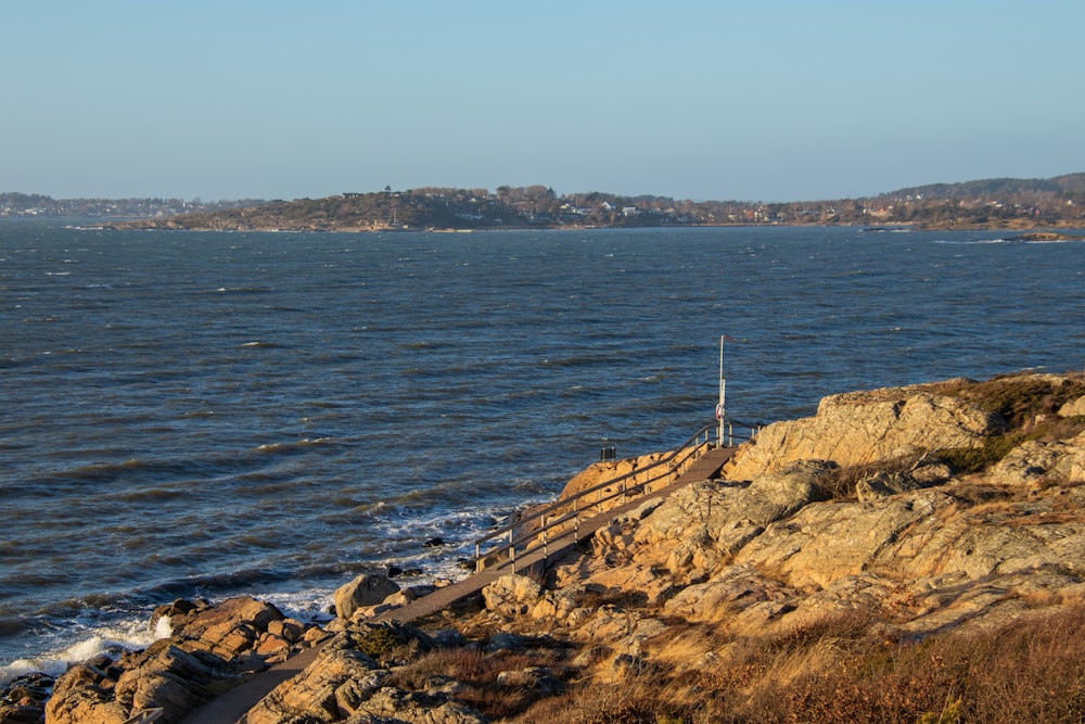 a large body of water sitting next to a rocky shore