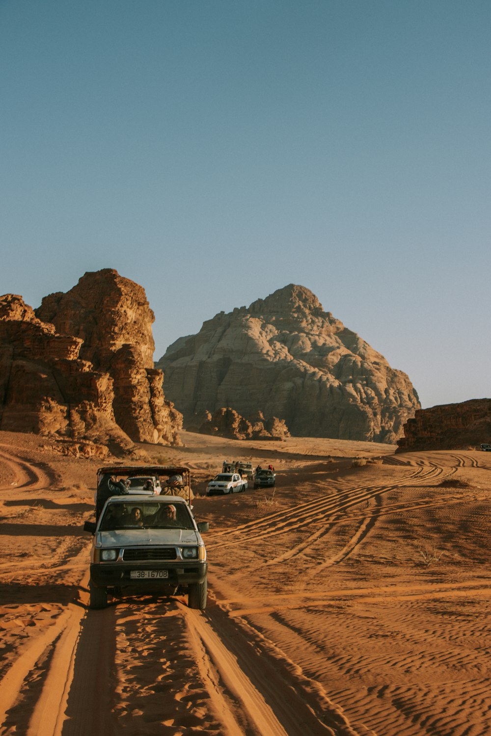 a jeep driving down a dirt road in the desert