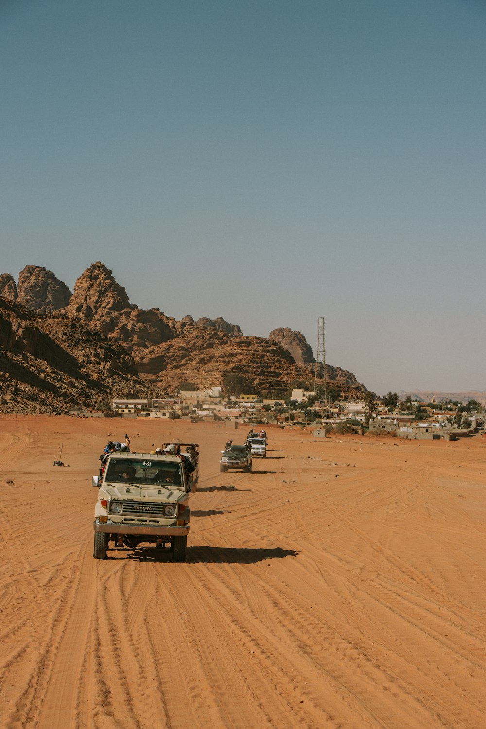 a group of vehicles driving on a dirt road