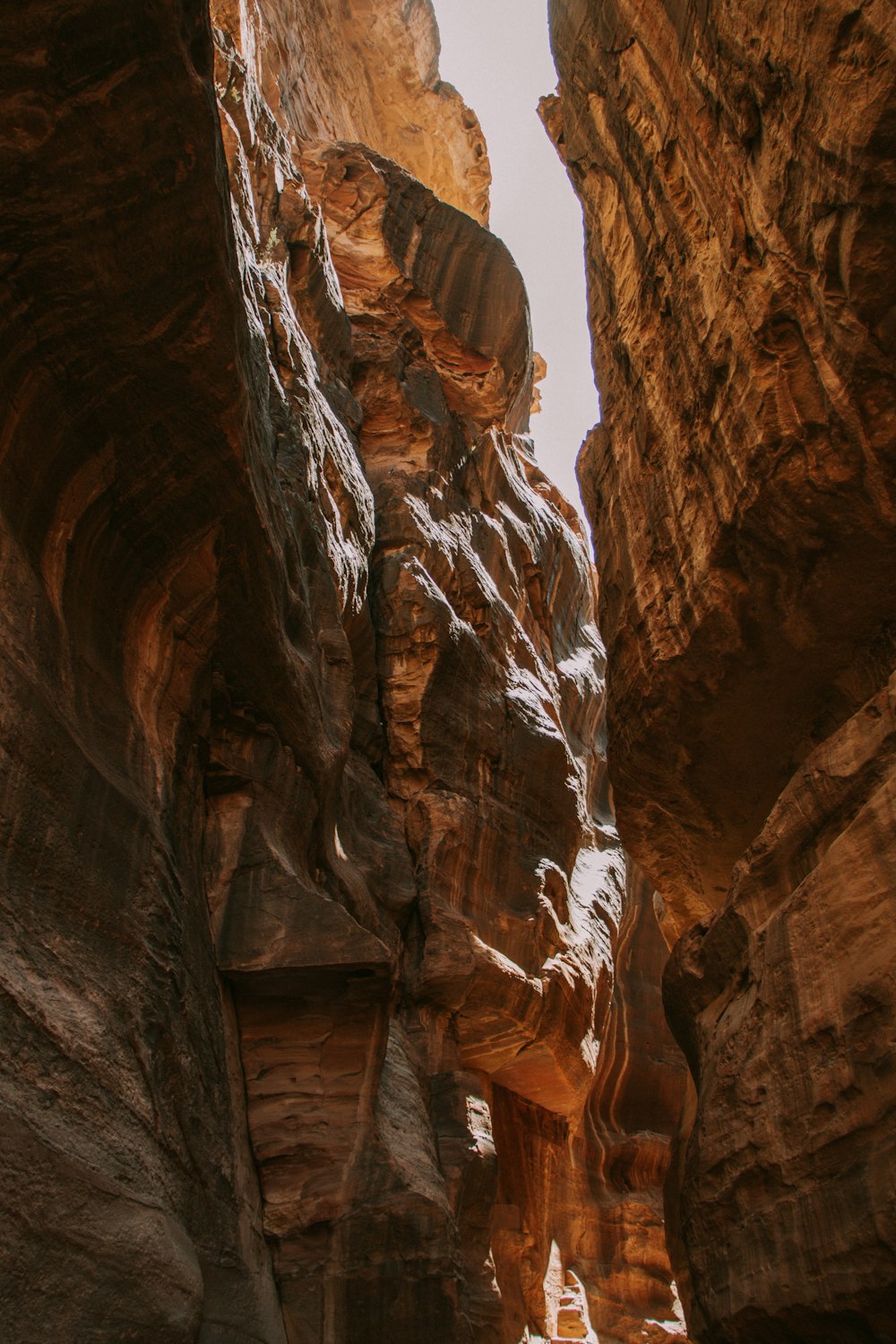 a narrow narrow canyon with a person walking through it