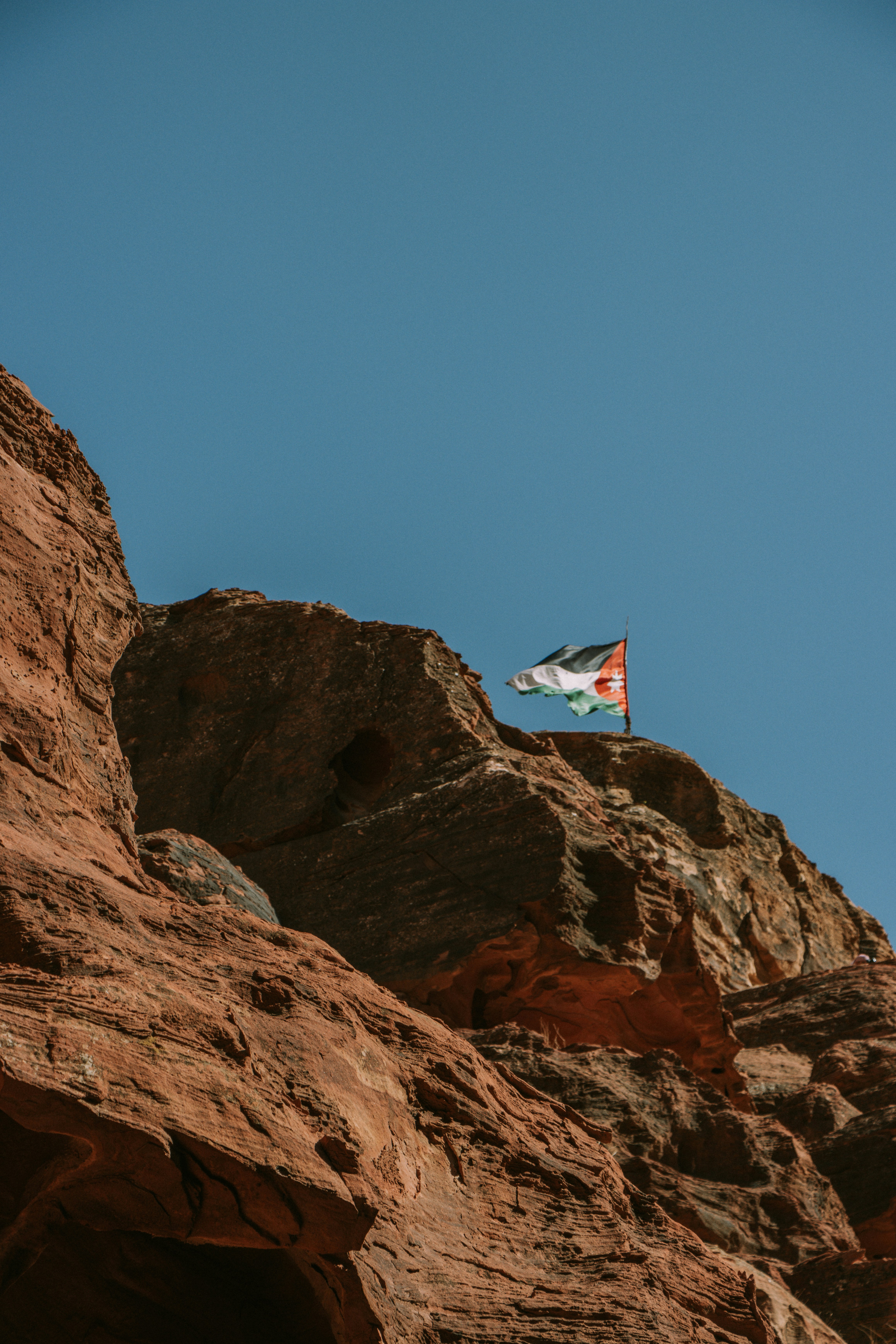 a flag flying on top of a rocky mountain