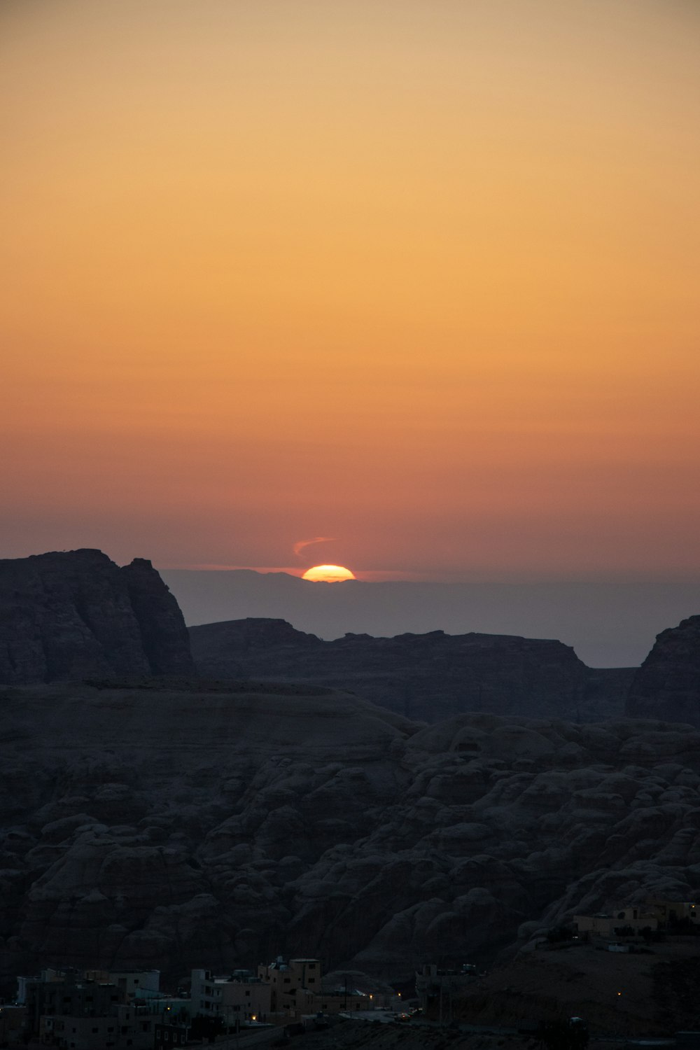 the sun is setting over the mountains in the desert