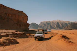 Guides leading an off-road adventure through dramatic desert landscapes under a bright blue sky.