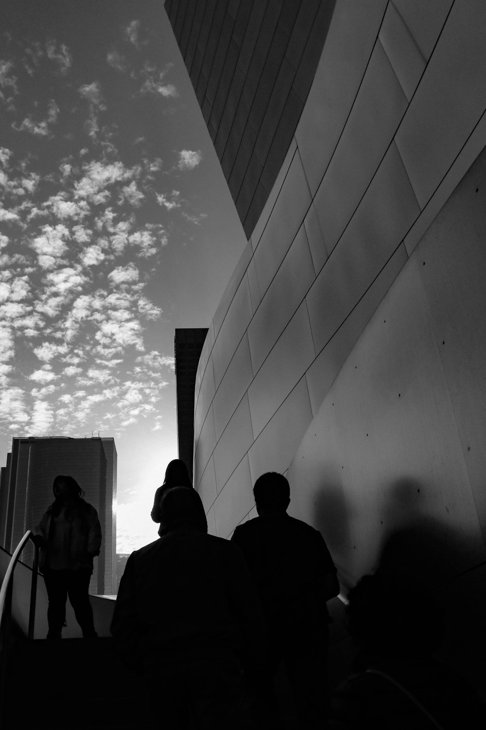 a group of people standing next to a tall building