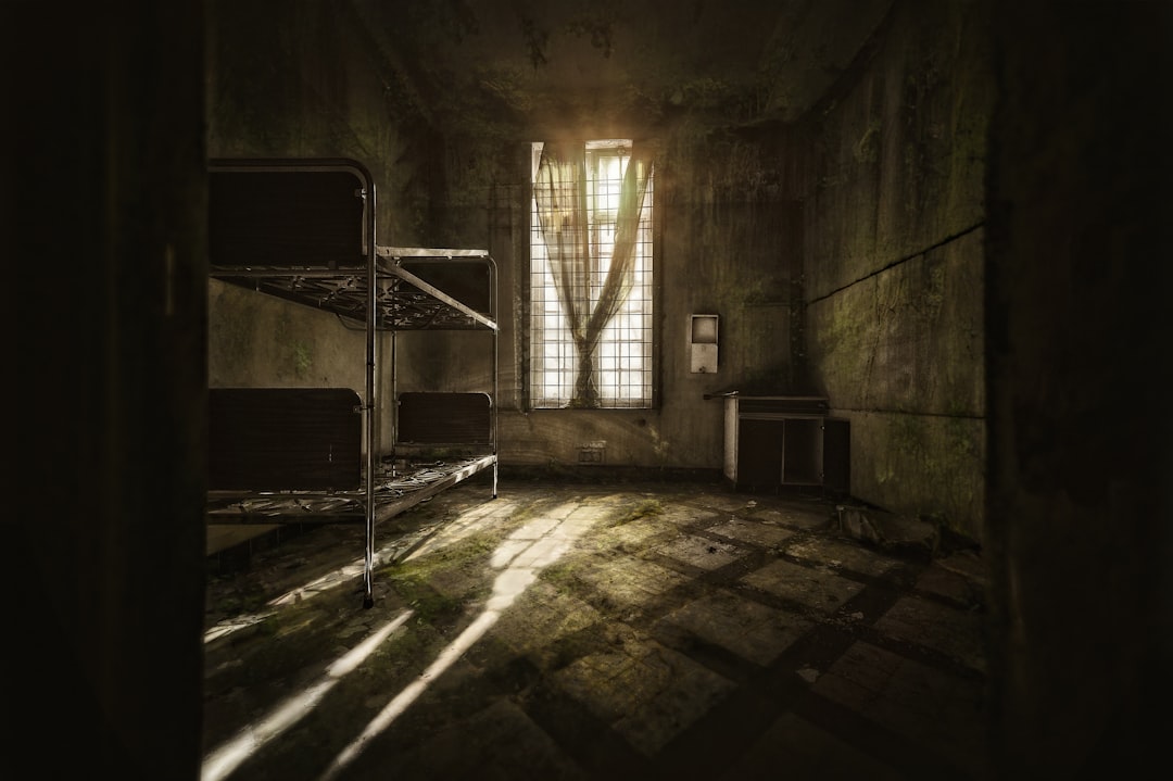 a dimly lit room with bunk beds and a window, A bedroom...