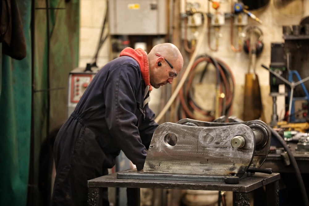 a man working on a metal object in a shop