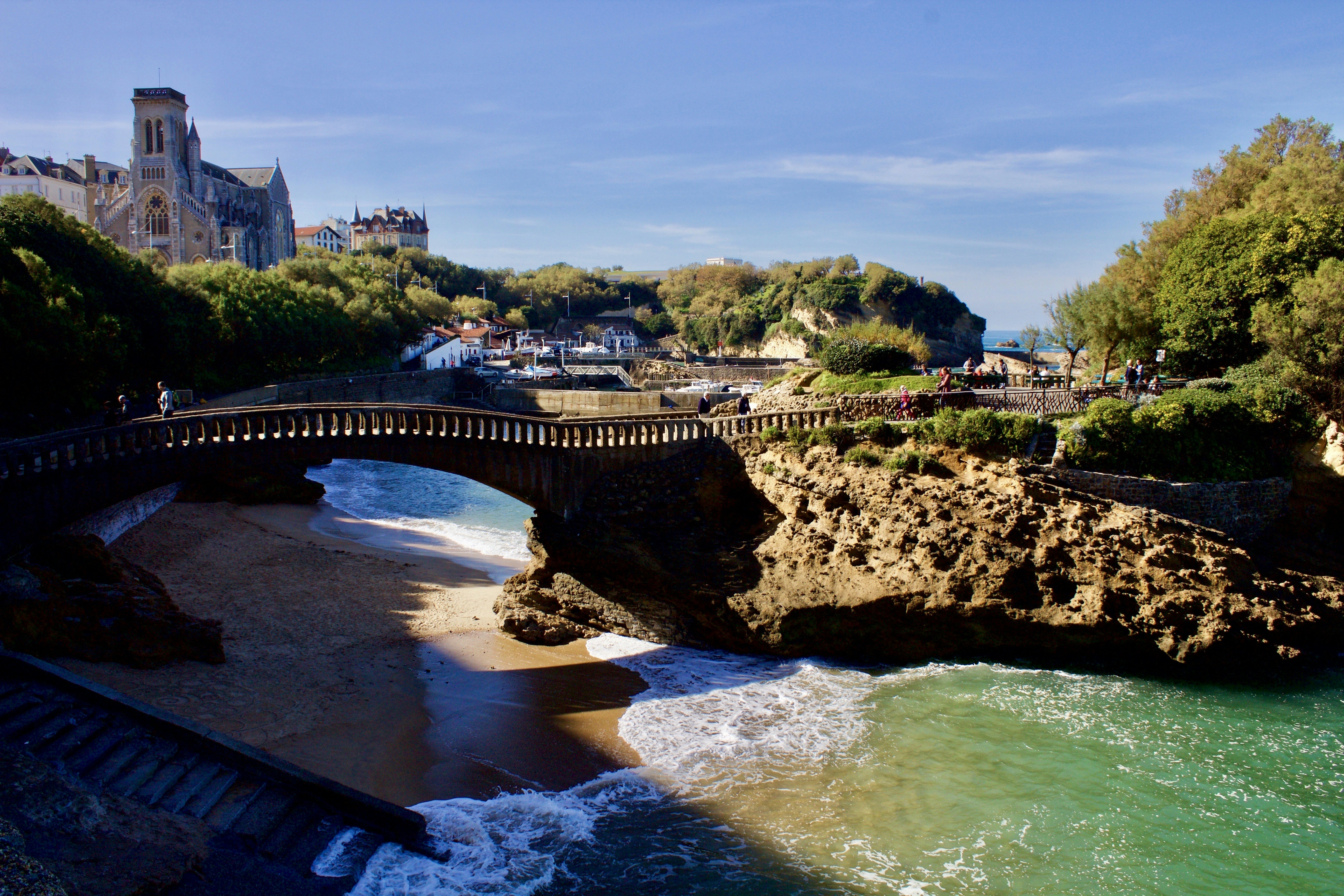 a bridge over a body of water next to a beach