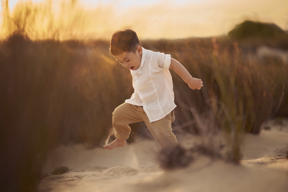 a young boy is playing in the sand