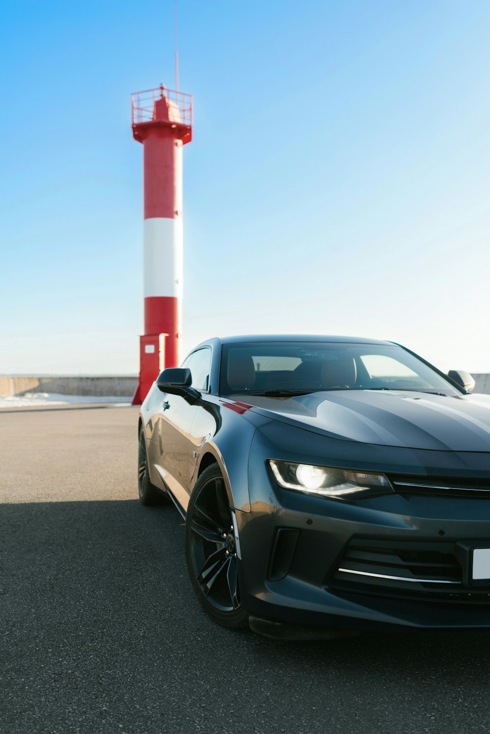 a car parked in front of a light house