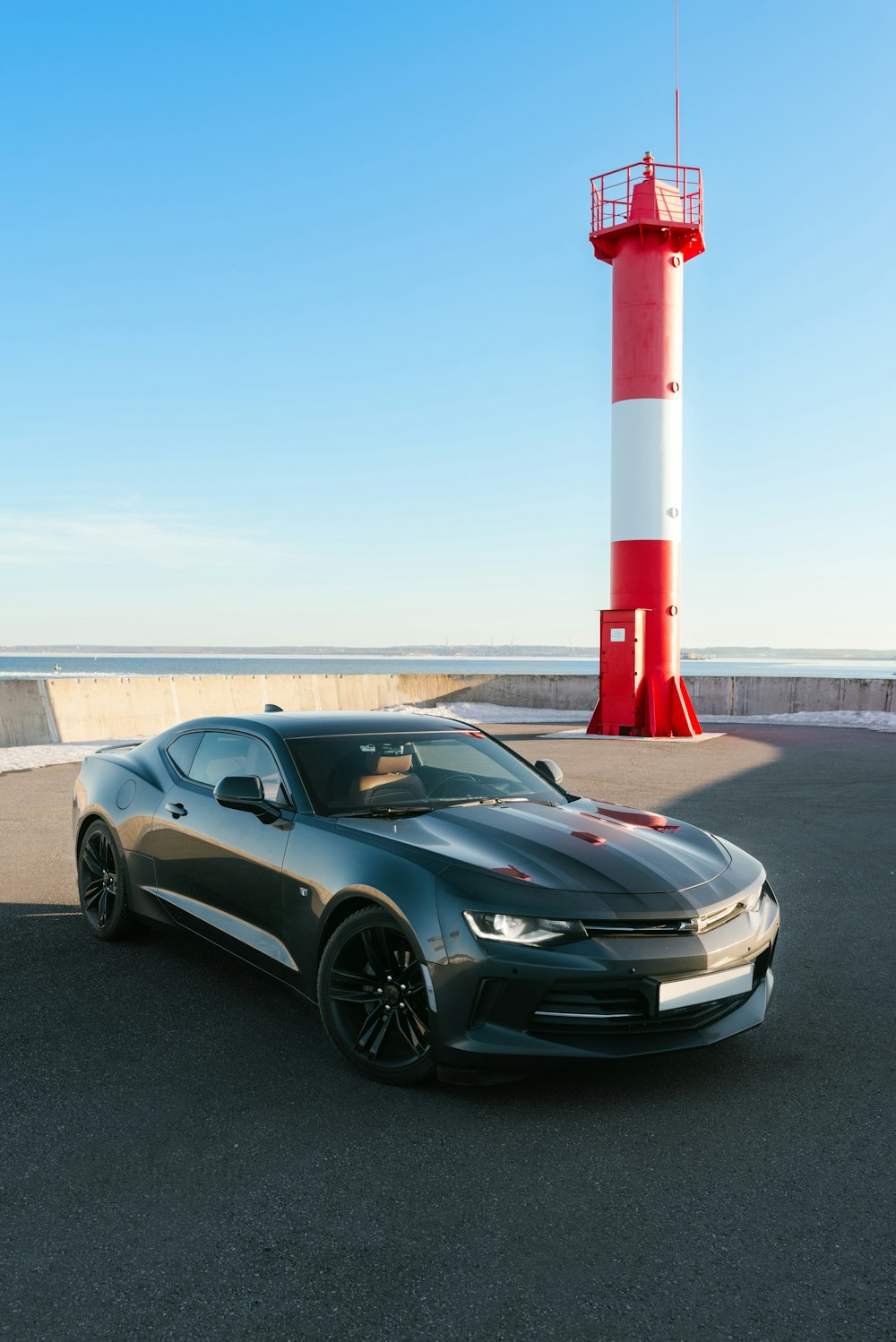 a car parked in front of a light house