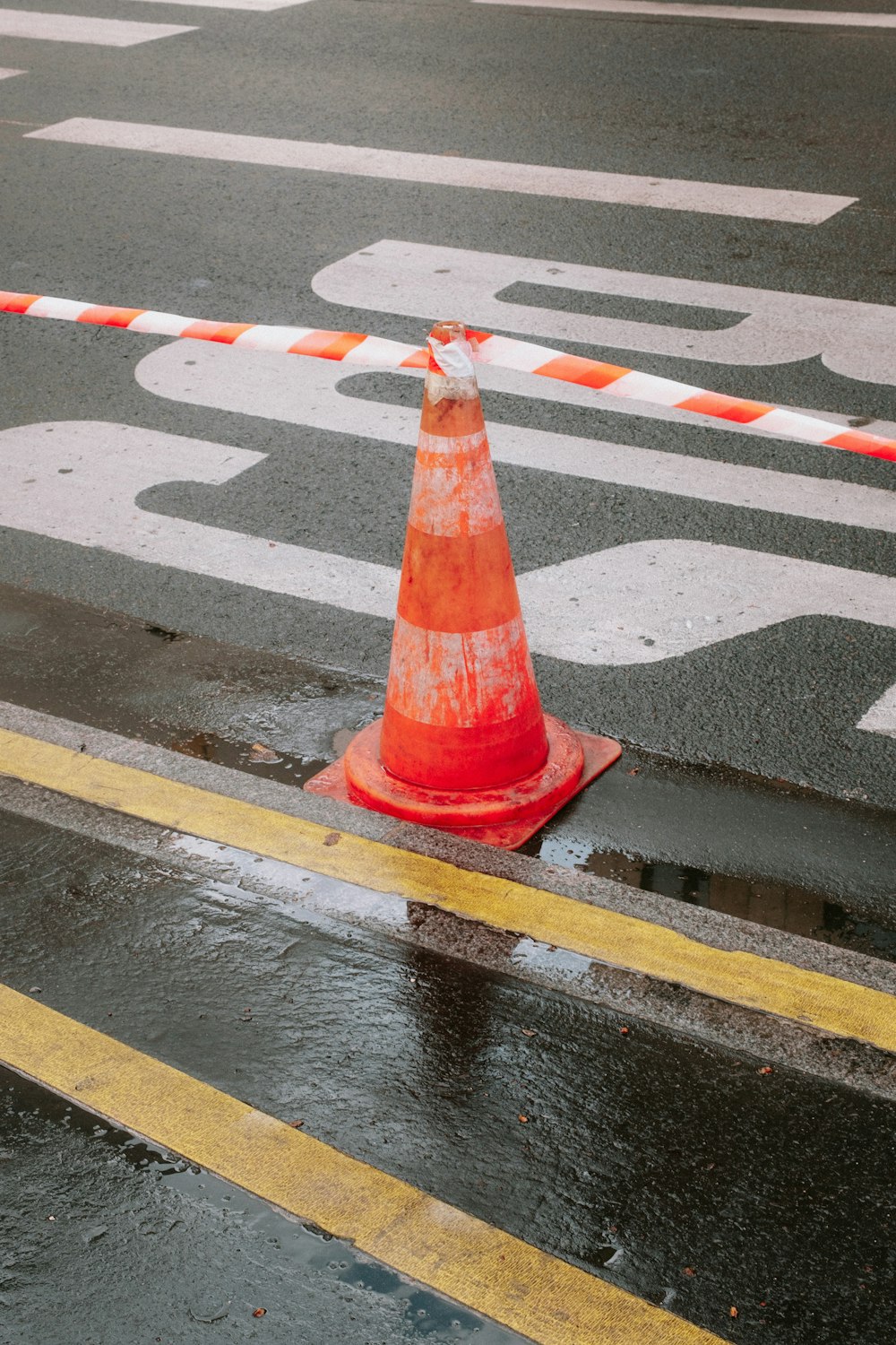 an orange traffic cone sitting on the side of a road