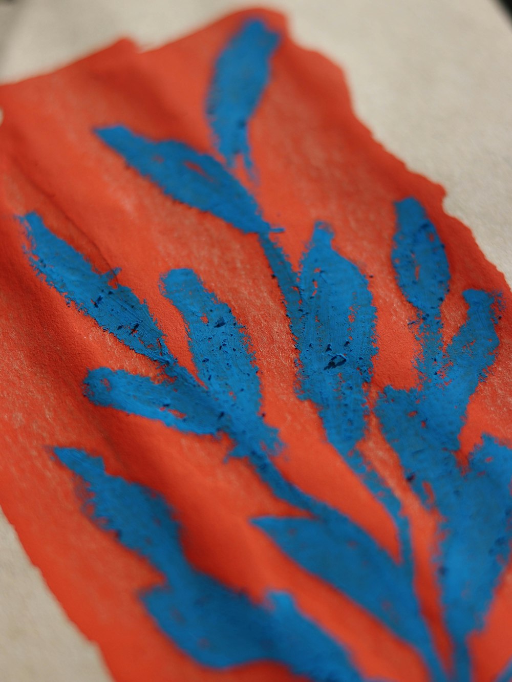 a red and blue piece of paper with blue flowers on it