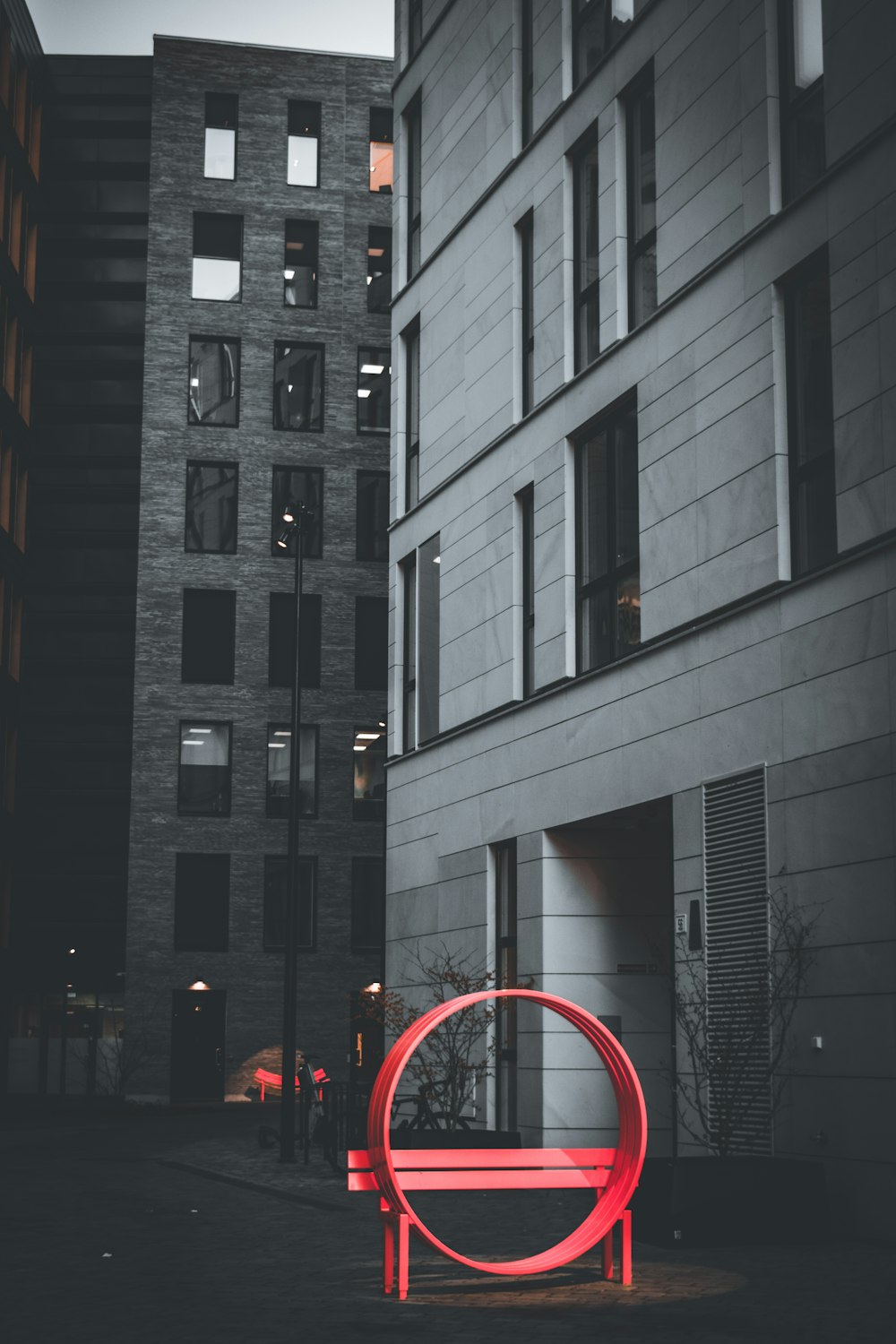 a red bench sitting in front of a tall building