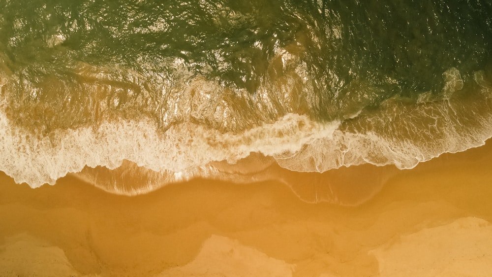 an aerial view of a beach with waves and sand