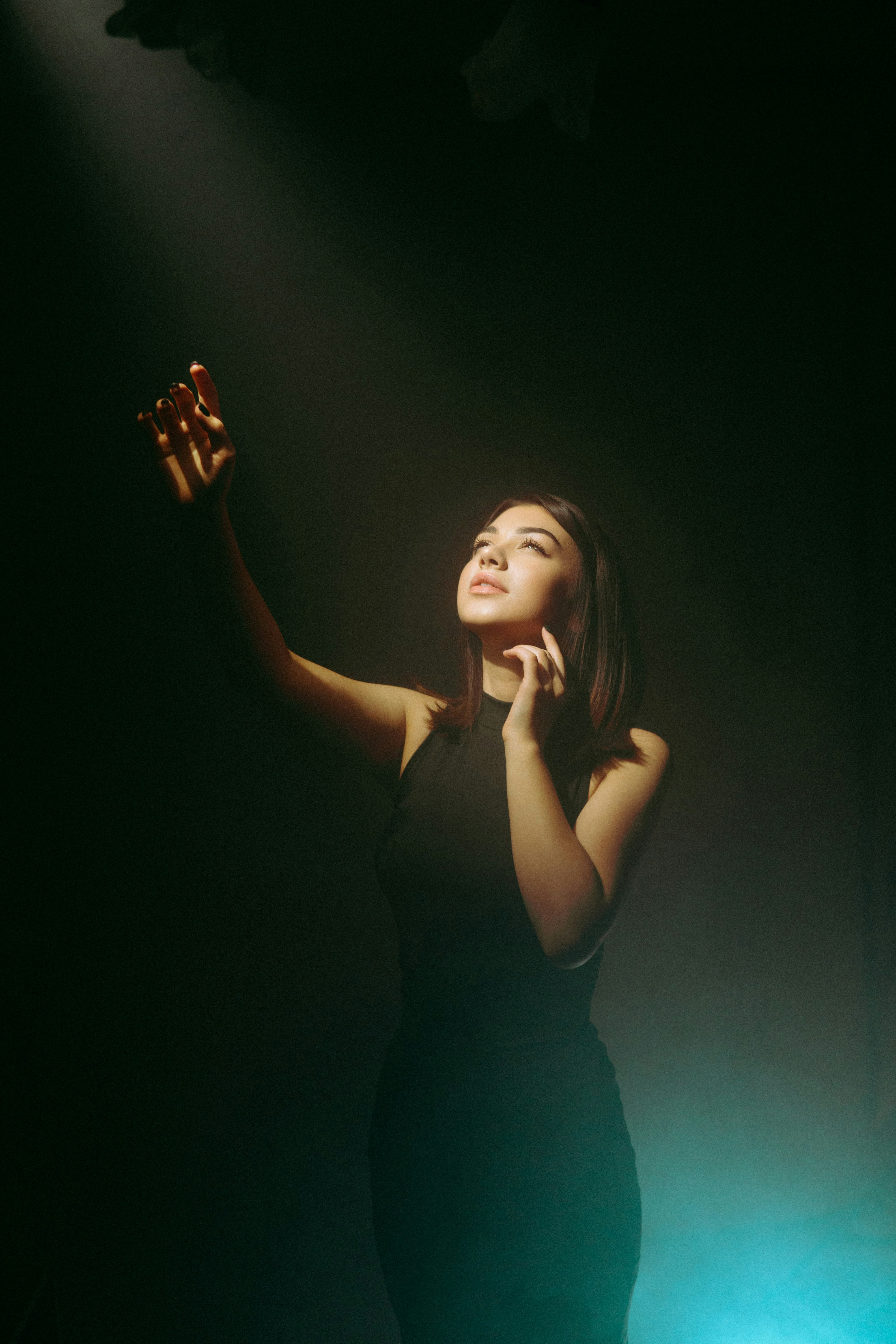 A woman in a black dress holding her hand up photo – Free Black Image ...