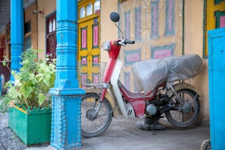 A vibrant blue building in Chefchaouen with a motorcycle parked nearby.