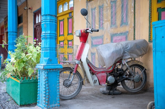 A vibrant blue building in Chefchaouen with a motorcycle parked nearby.