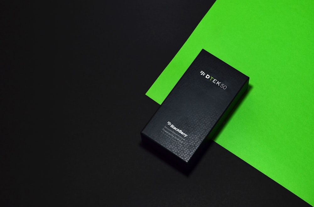a black box sitting on top of a green and black table