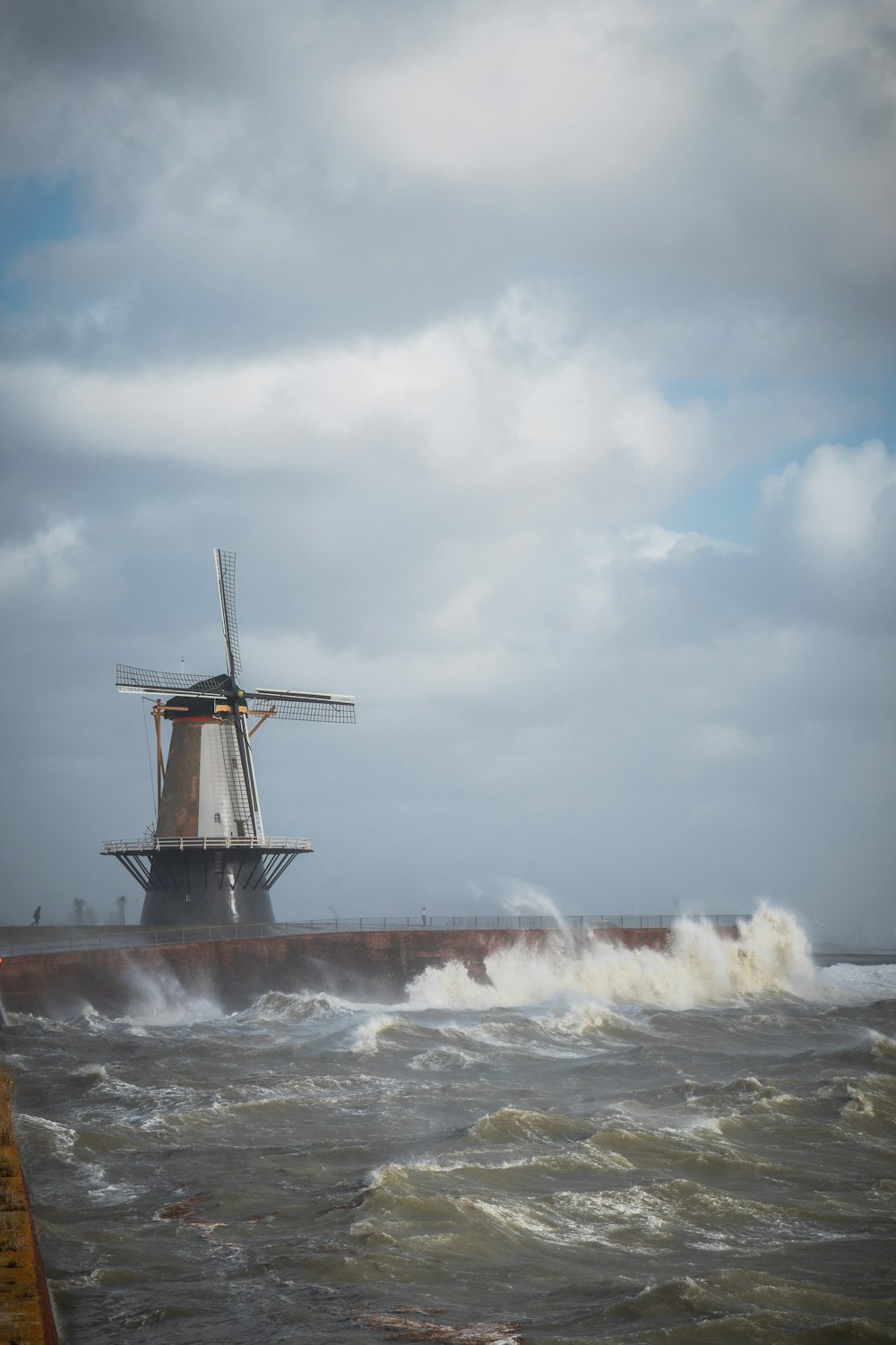 eine Windmühle mitten in einem großen Gewässer