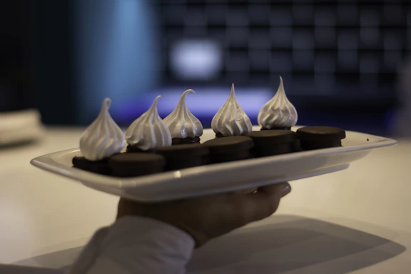 a person is holding a plate with chocolates on it