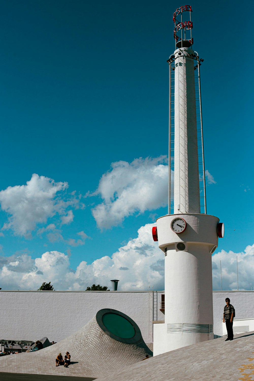 a tall white tower with a clock on it's side