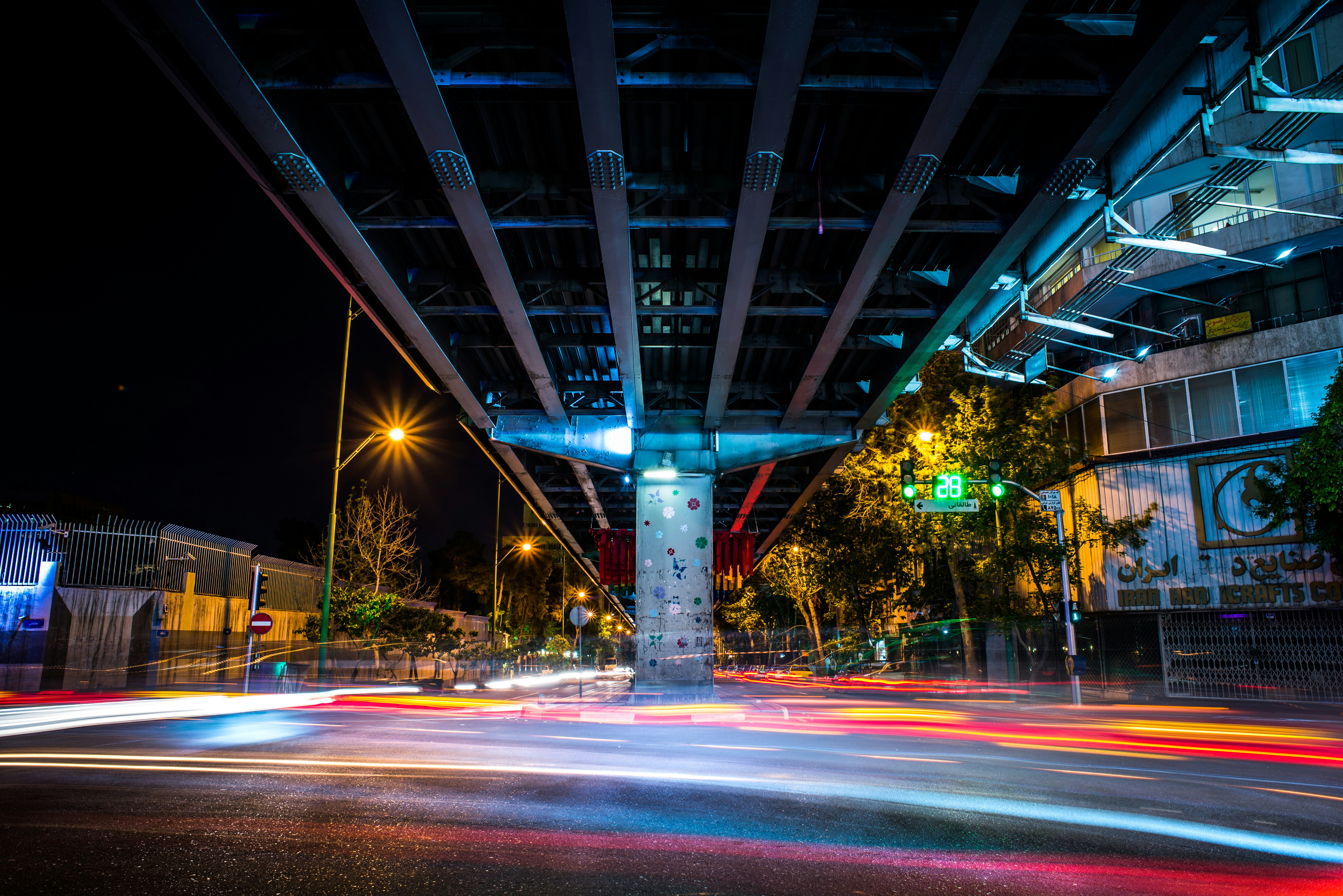 a city street filled with lots of traffic under a bridge