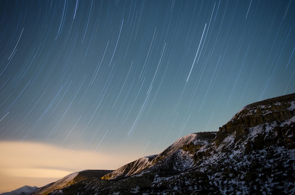 a mountain with a star trail in the sky