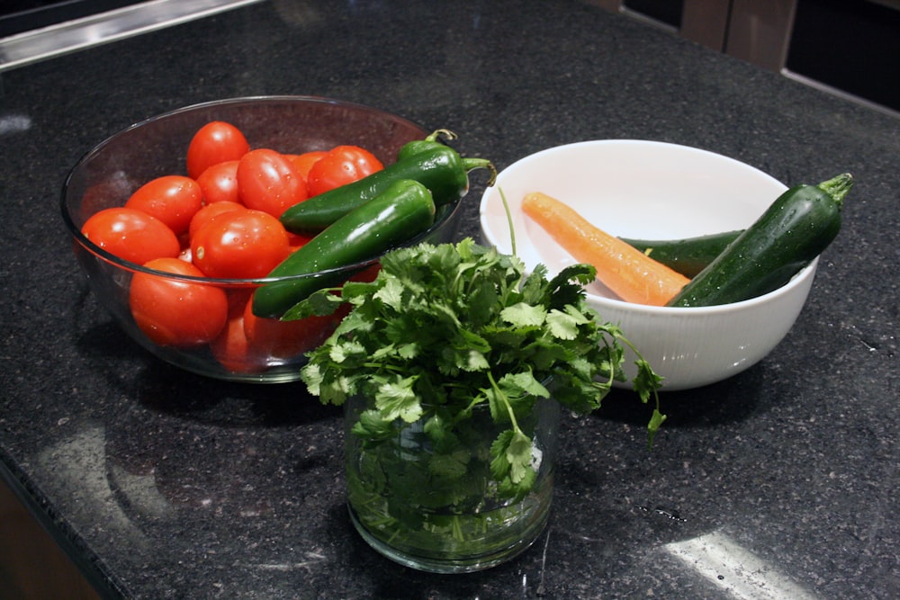 a bowl of tomatoes, cucumbers, carrots, and celery