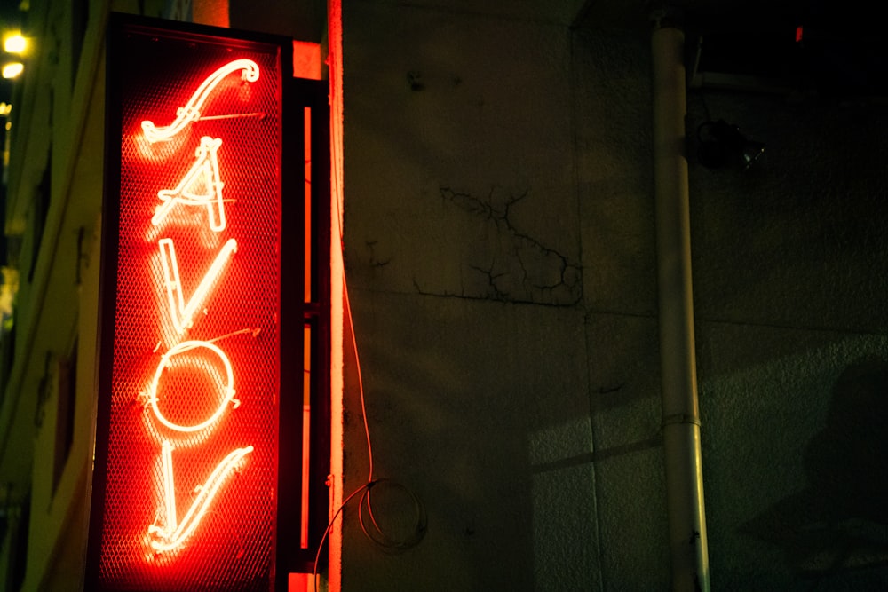 a neon sign that says avocado on the side of a building