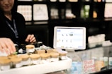 a woman standing behind a counter with a tablet