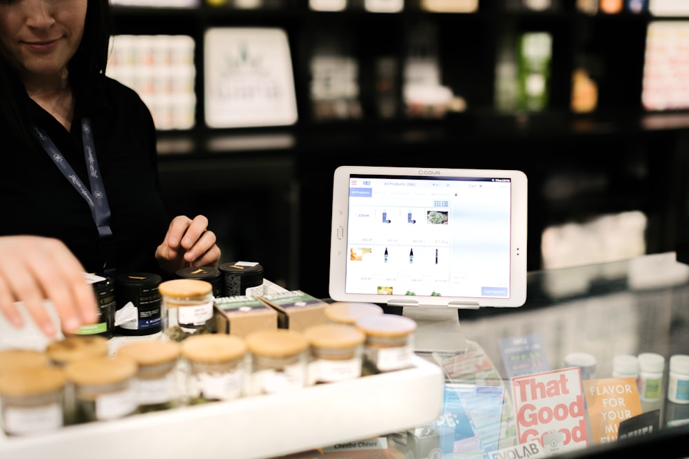 a woman standing behind a counter with a tablet