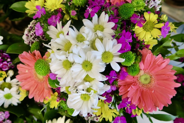 A festive mix of bright tulips and daisies arranged in a colorful, cheerful bouquet for a joyful occasion.