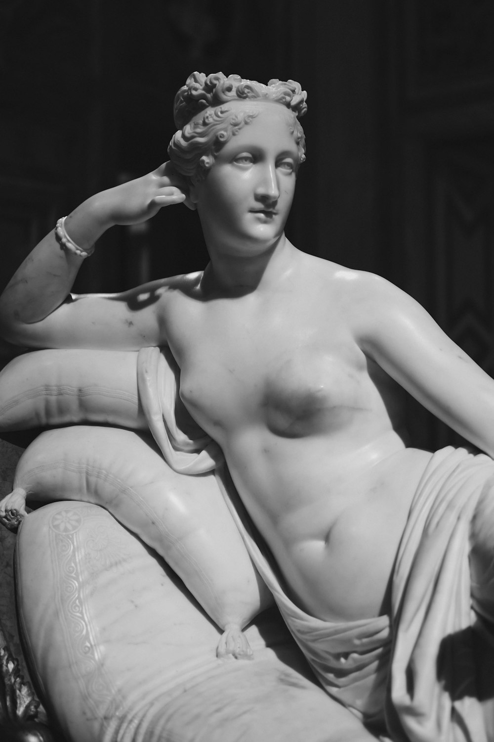 uma estátua de uma mulher sentada em cima de um sofá