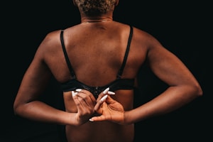 Woman adjusting her bra strap in front of a mirror