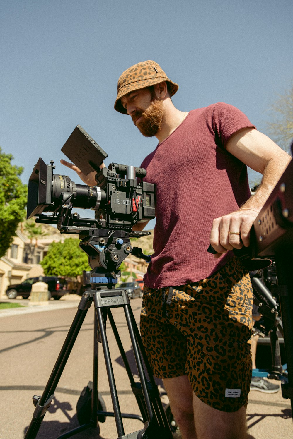 a man standing next to a camera on a tripod