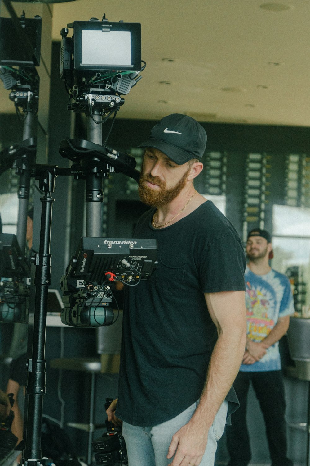 a man standing in front of a camera on a tripod