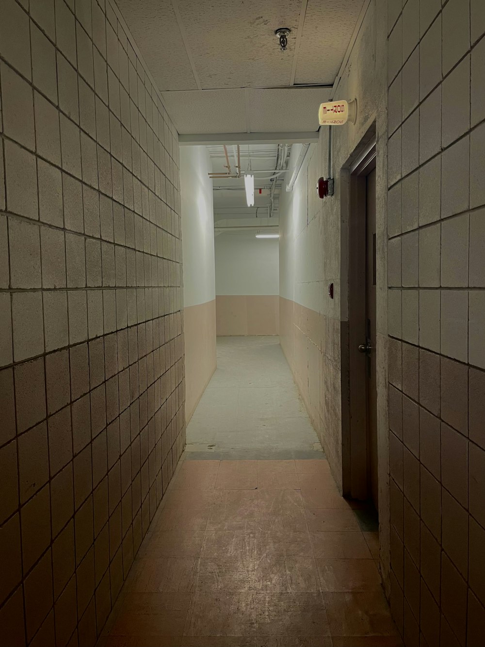 a long hallway with a door leading to another room