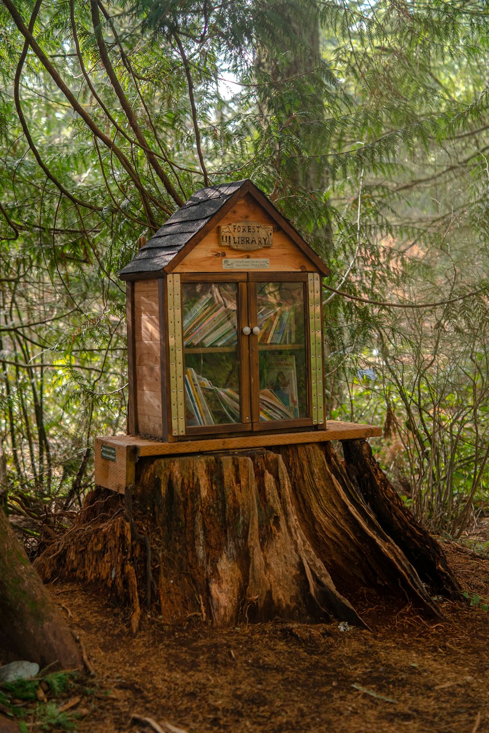 a tree stump with a small house on top of it