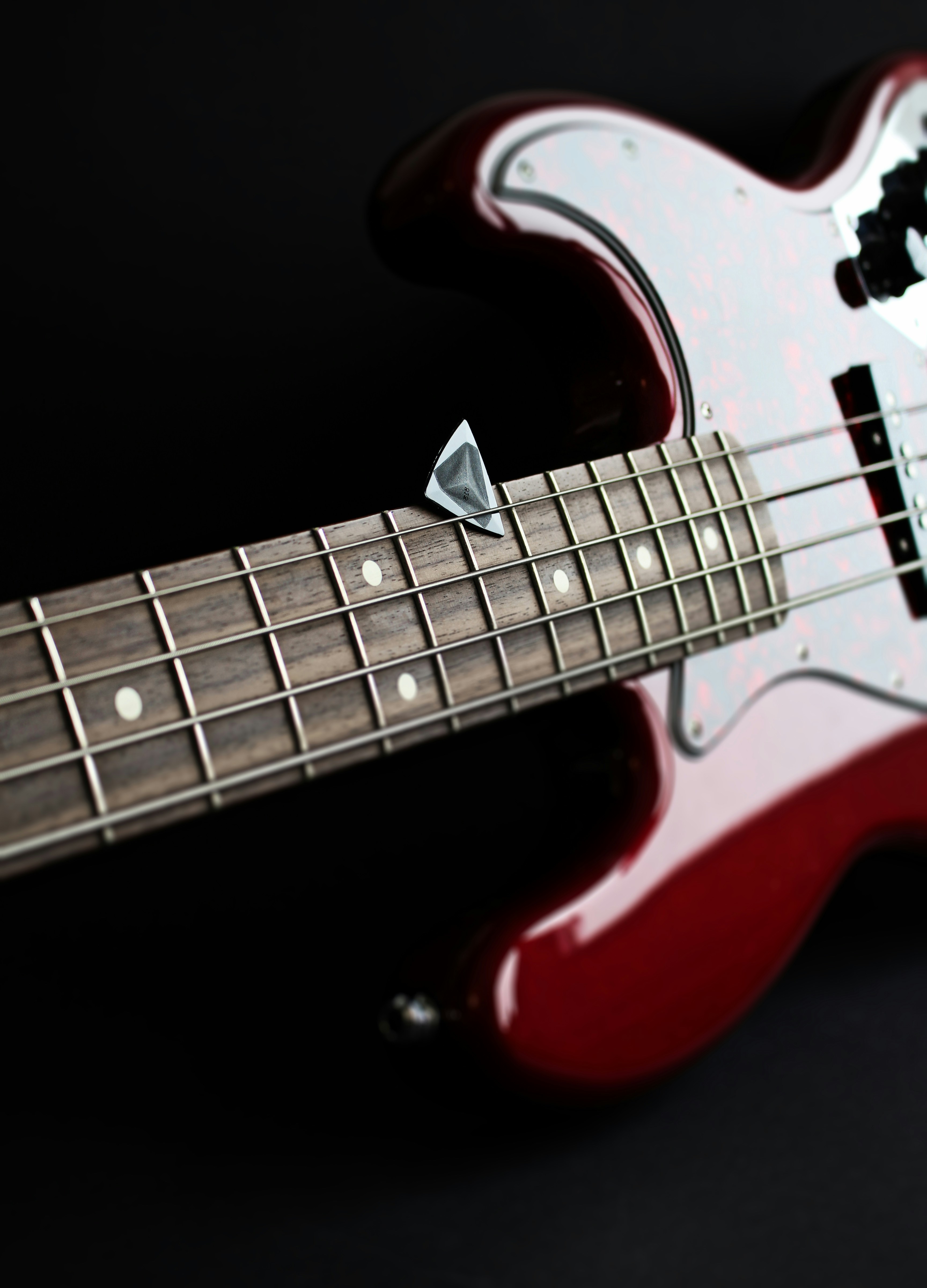 a red electric bass guitar with a black background