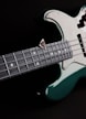 a close up of a green and white bass guitar