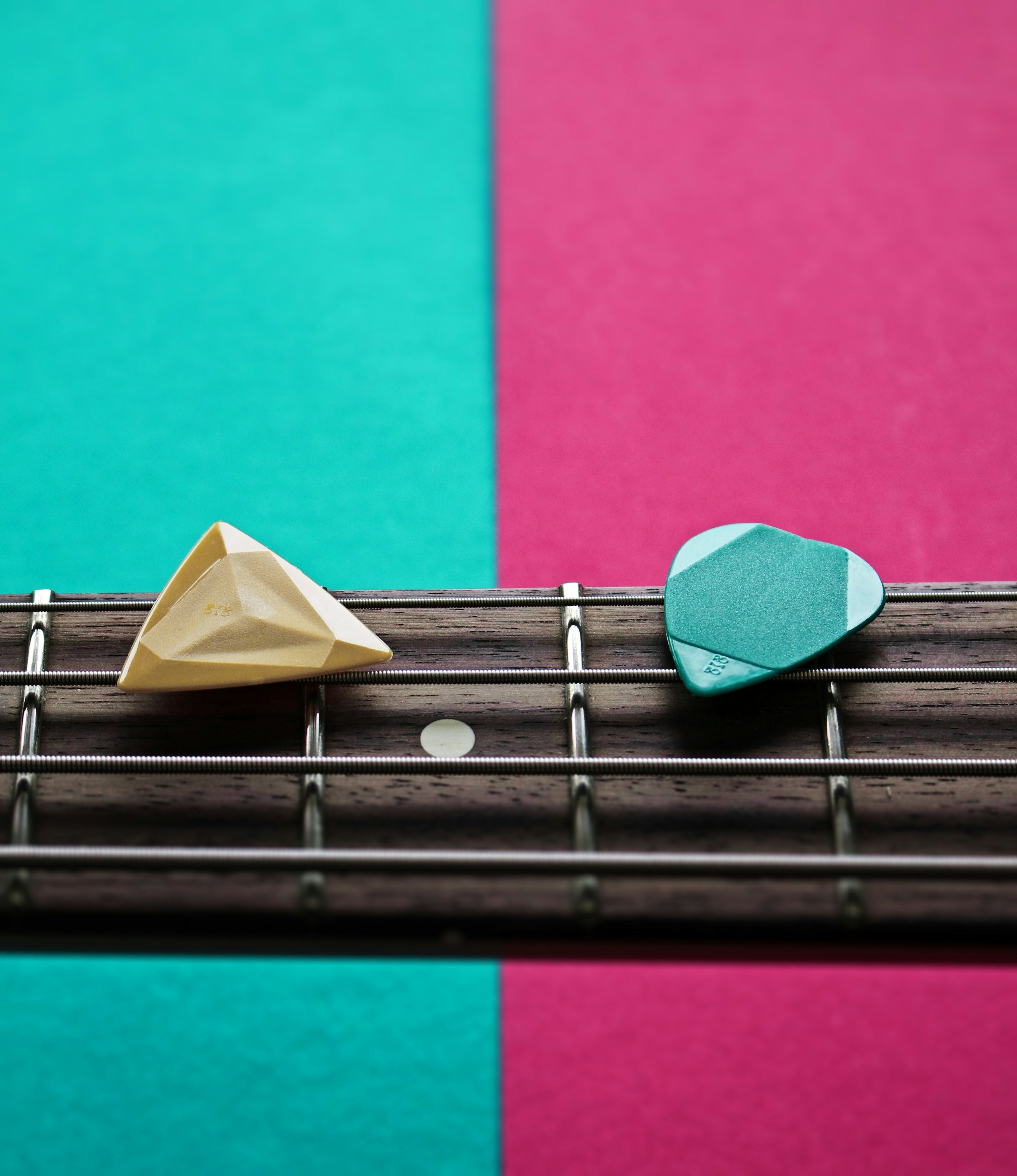 a close up of a guitar string with a paper boat on top of it