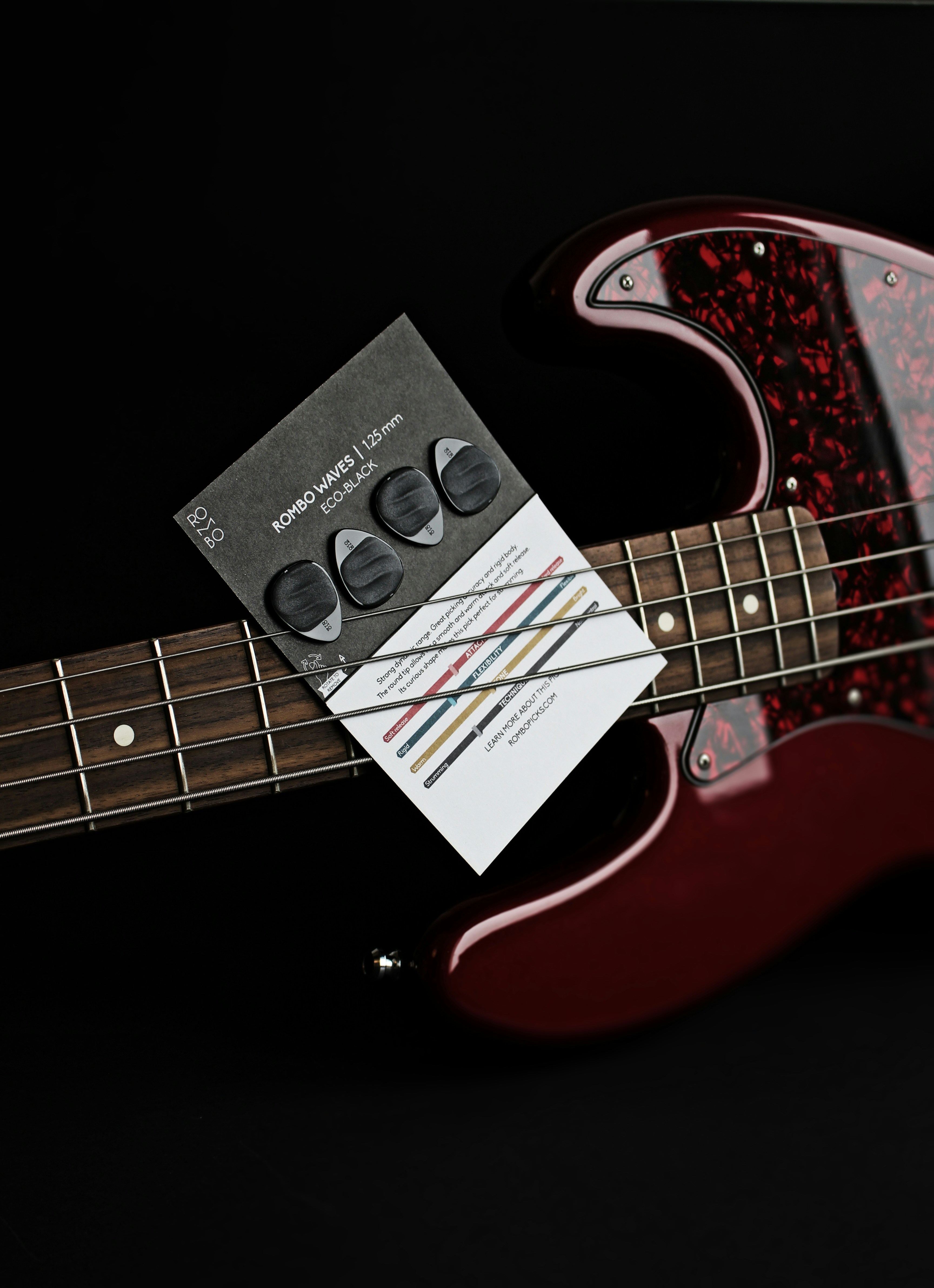 a red electric bass guitar with a black background