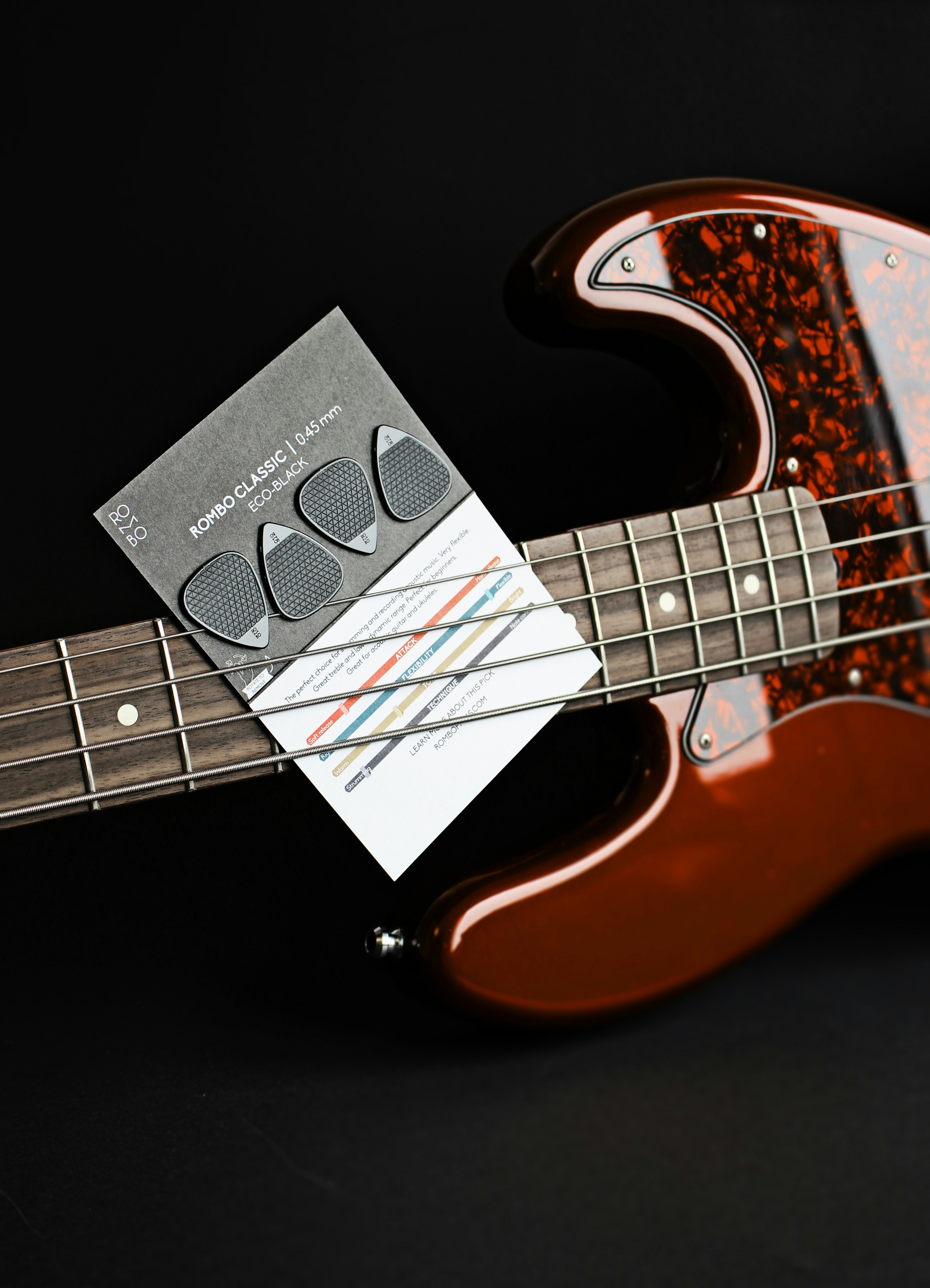 a red electric bass guitar with a note attached to it
