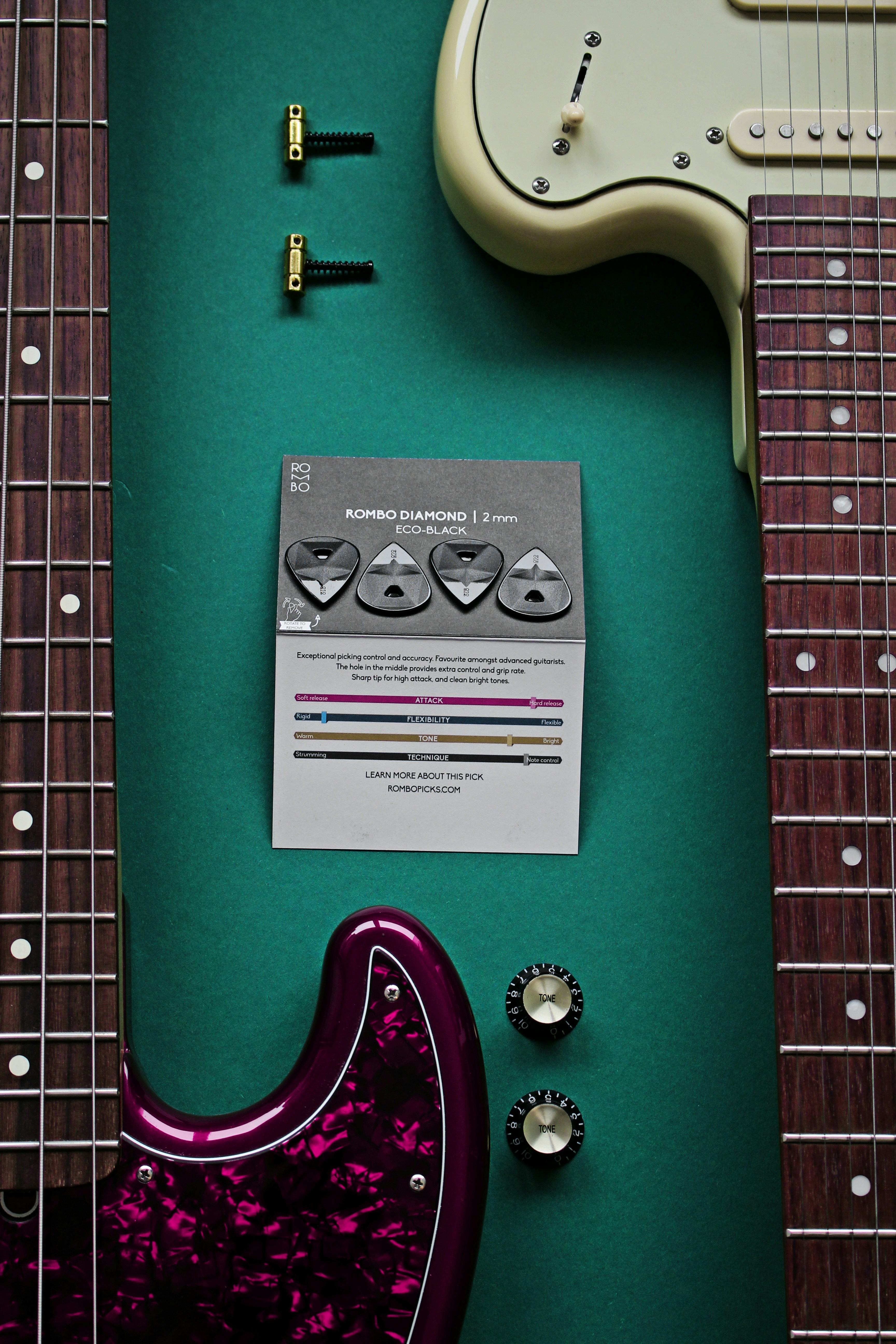 an electric guitar and a guitar tuner on a green surface